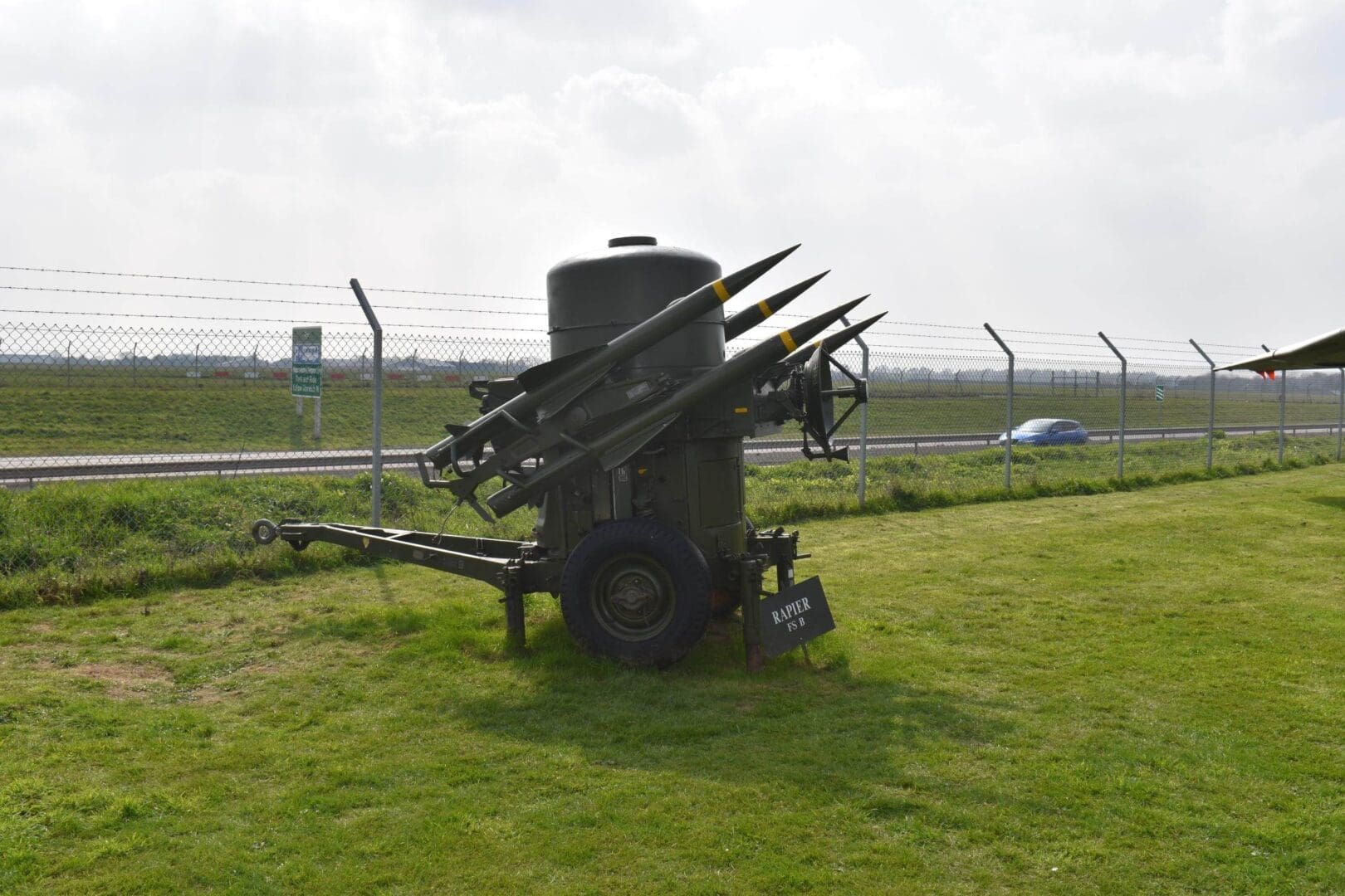 Military missile launcher on grassy field.