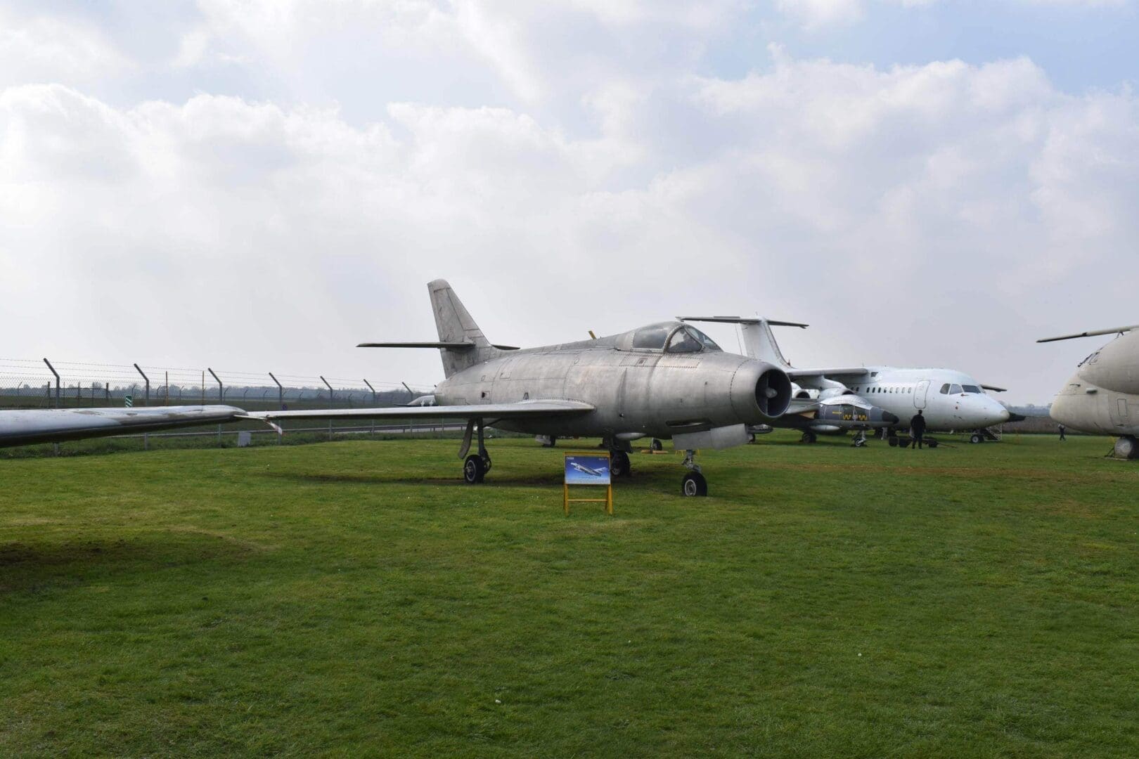 Vintage jet aircraft displayed on grass field.