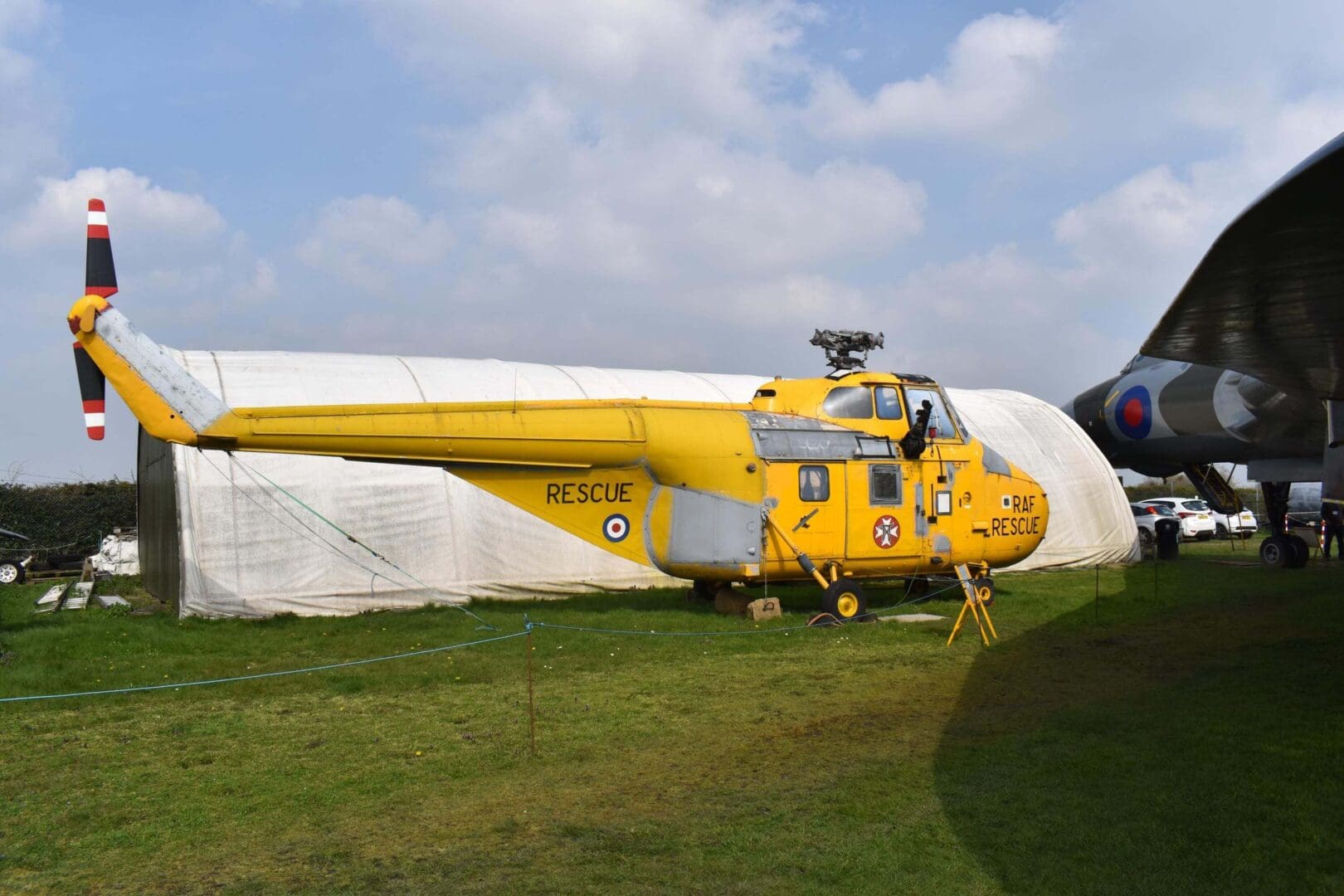 Yellow rescue helicopter parked on grass.