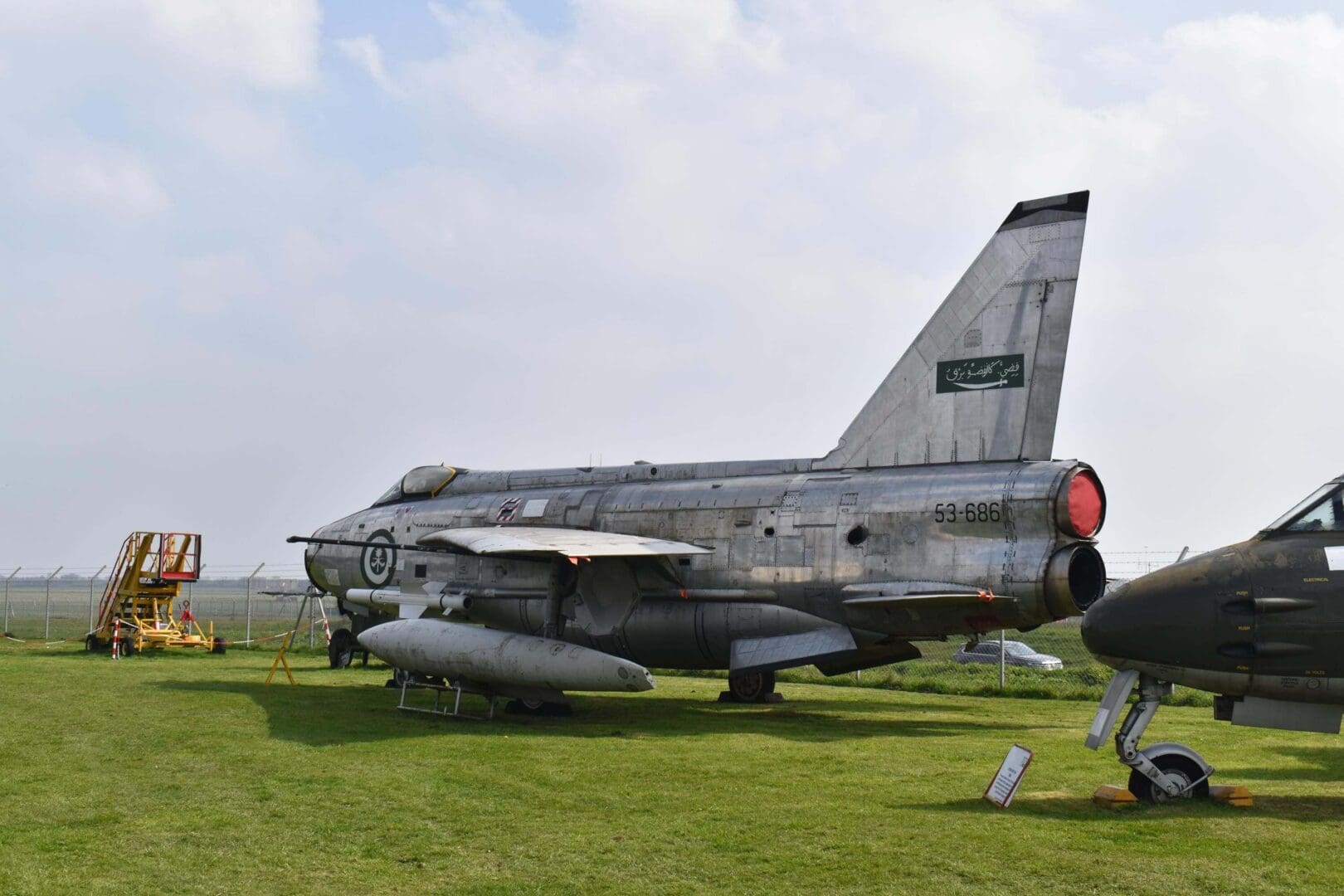 Vintage military jet displayed on grass field.