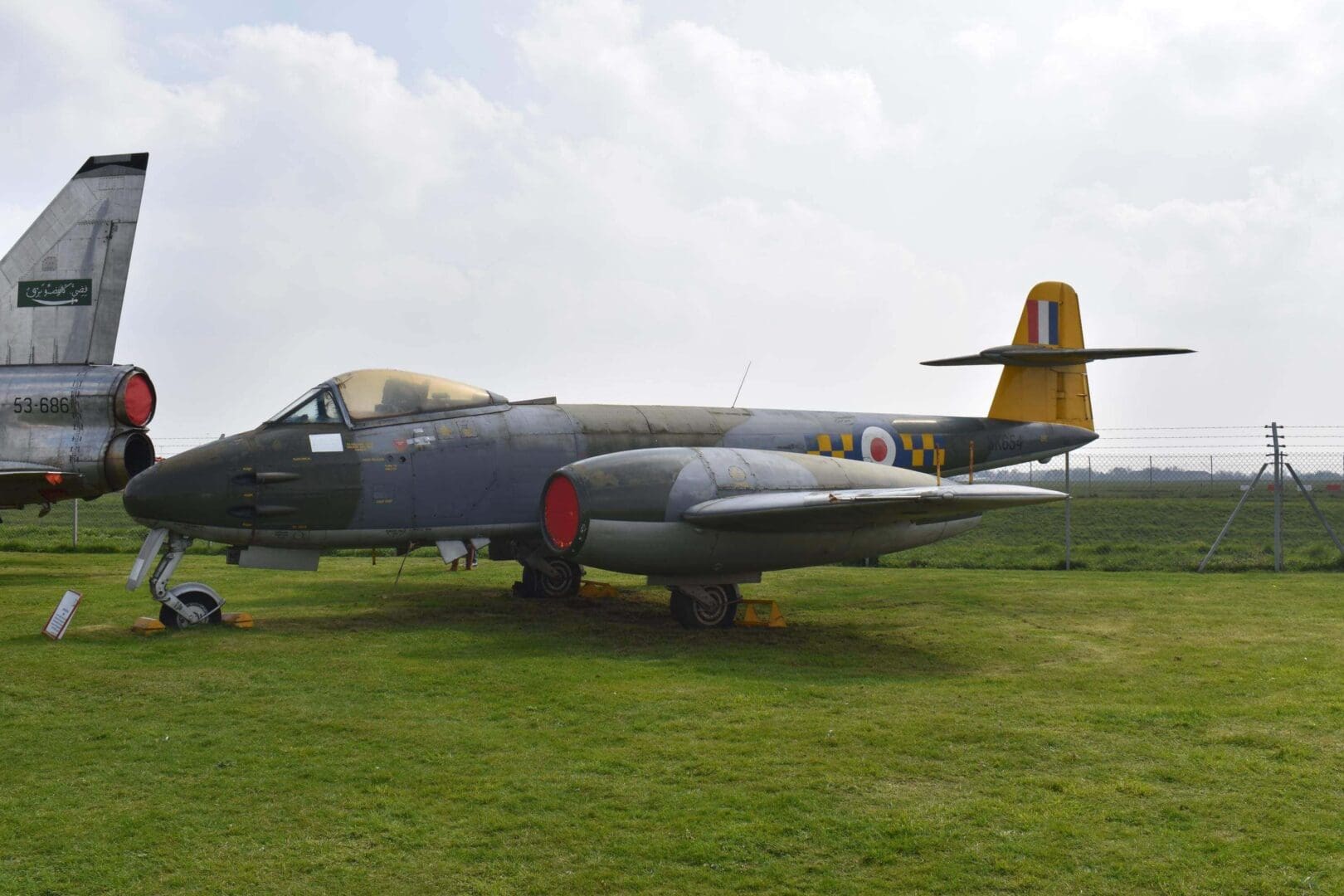 Vintage military jet displayed on grass field.