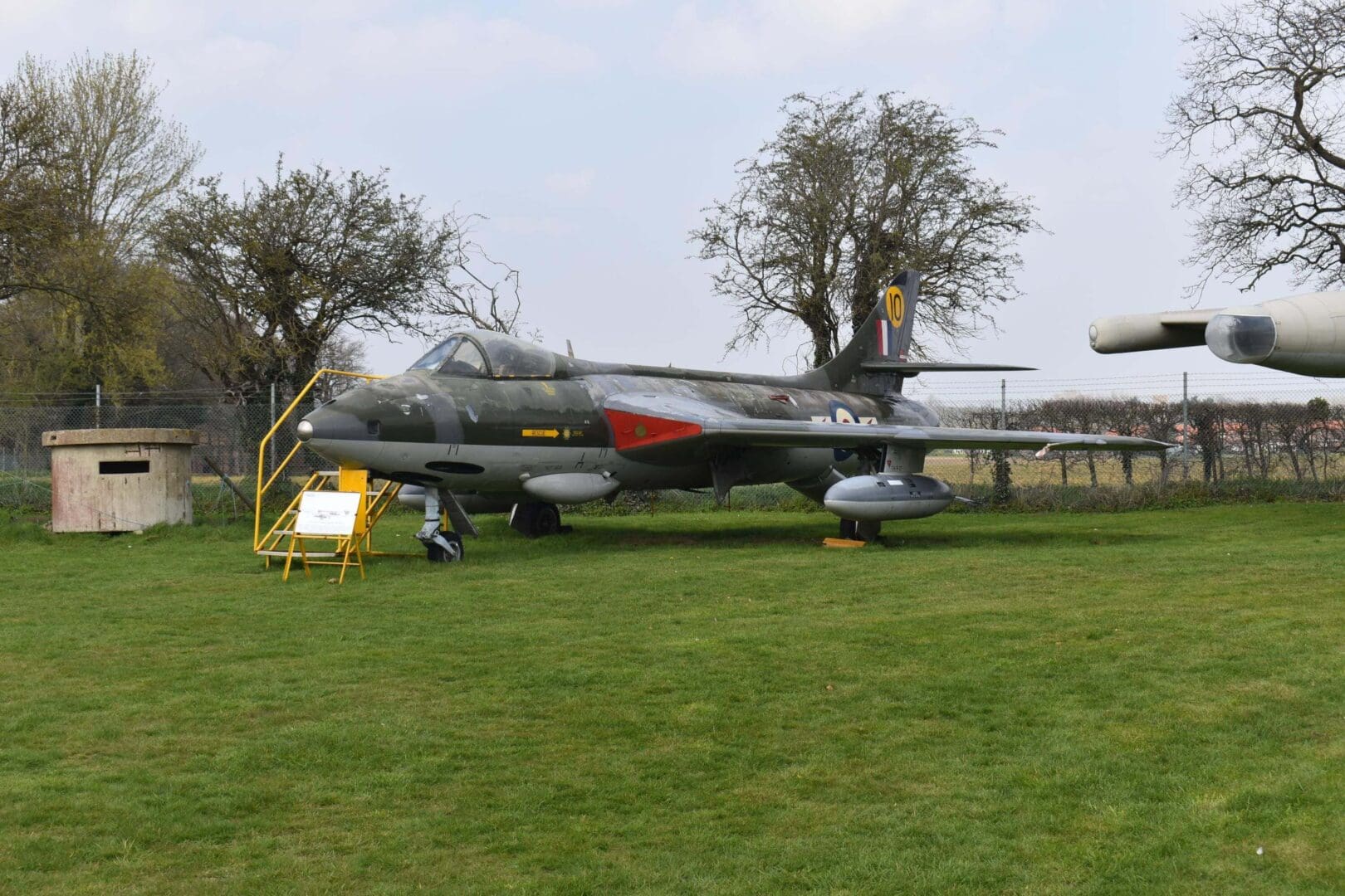 Military jet displayed on grassy field.