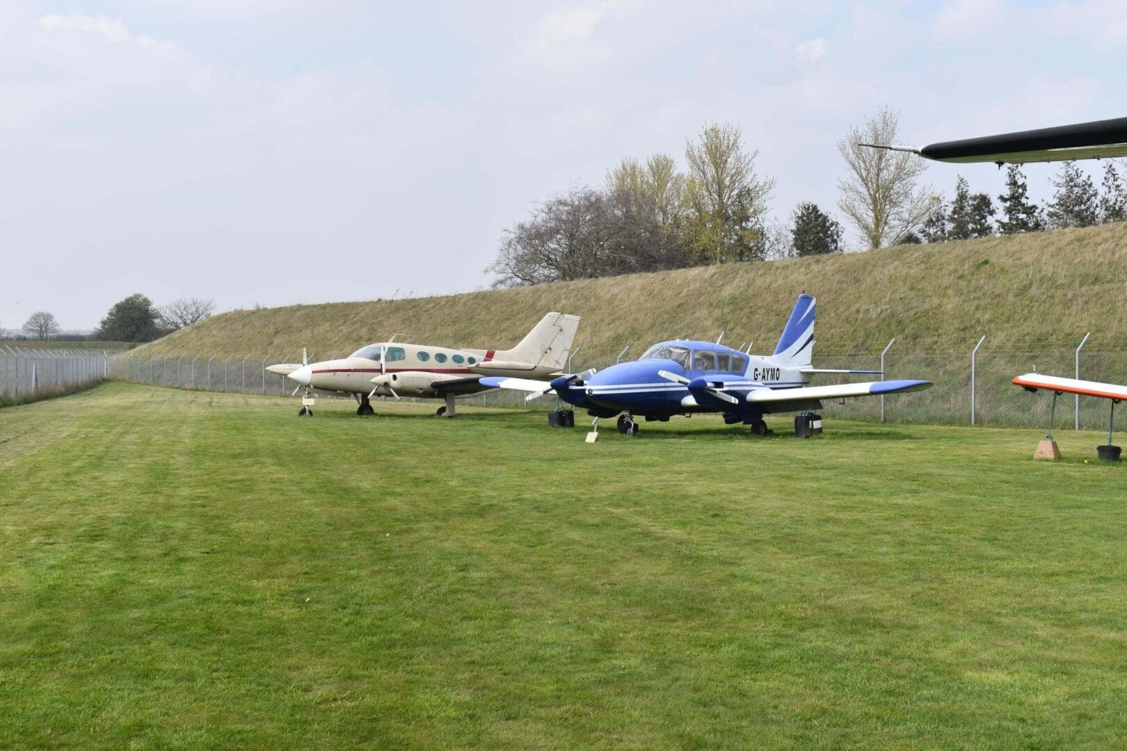 Small airplanes parked on grassy field.