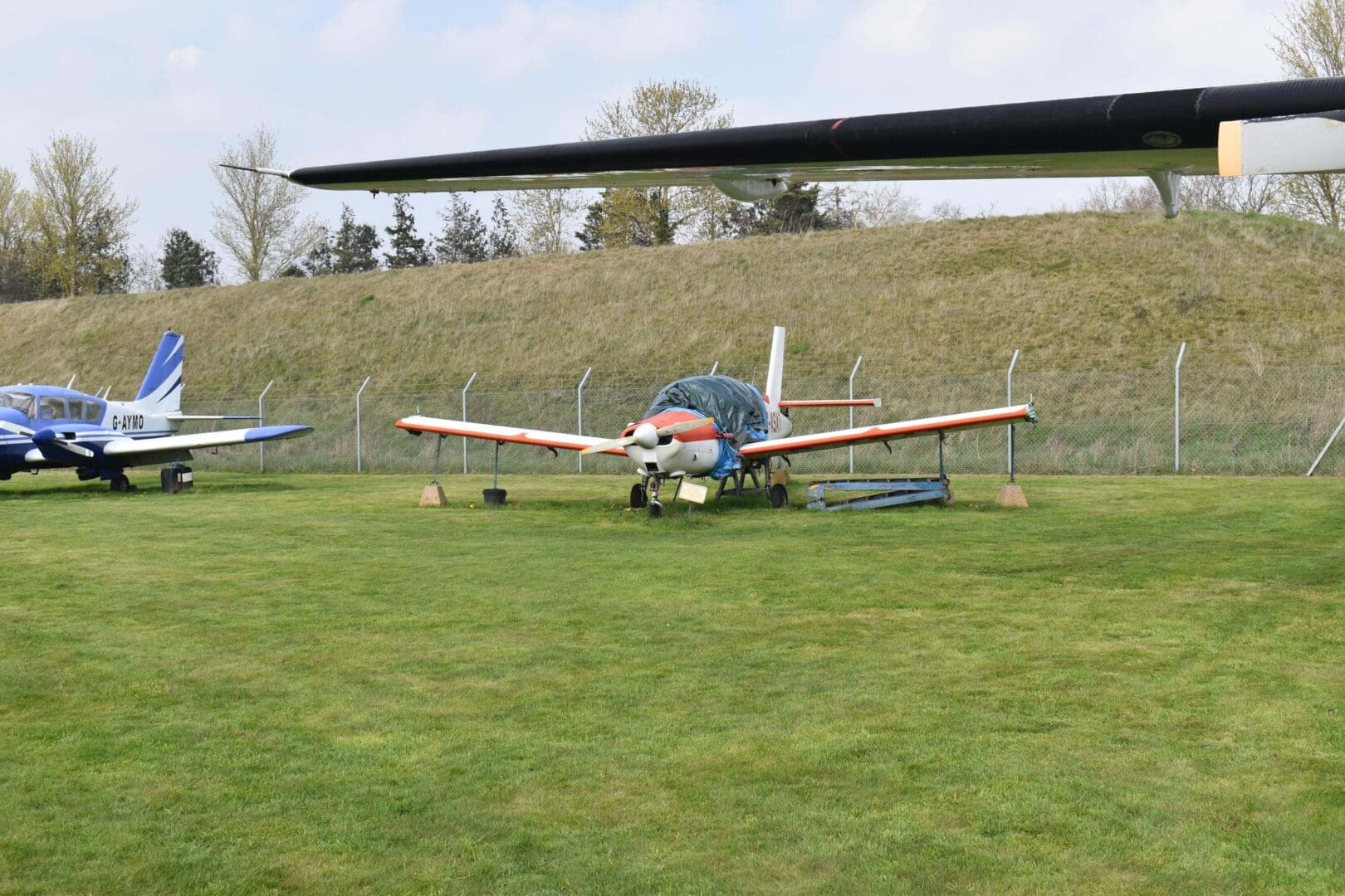 Small airplanes parked on grassy field.