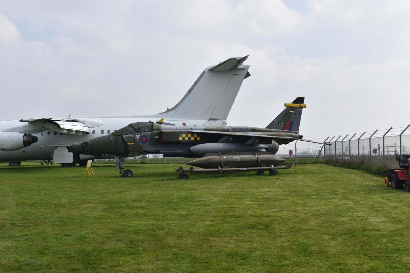 Military aircraft displayed on grassy field.