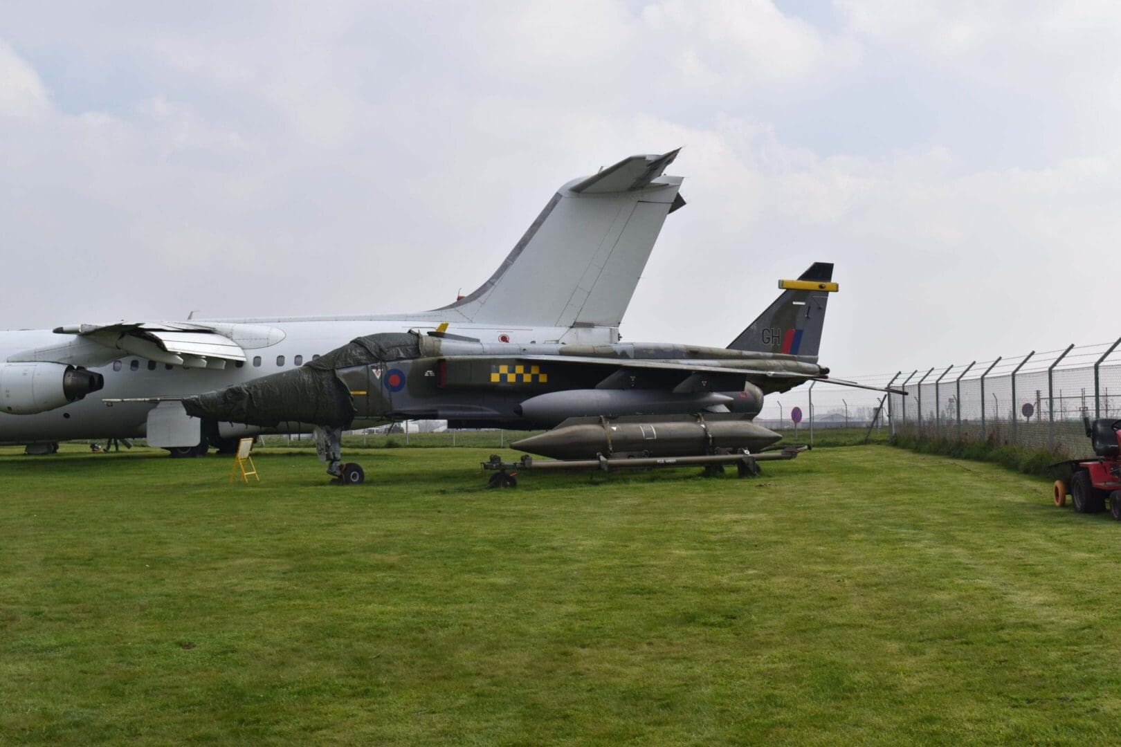Military aircraft displayed on grassy field.