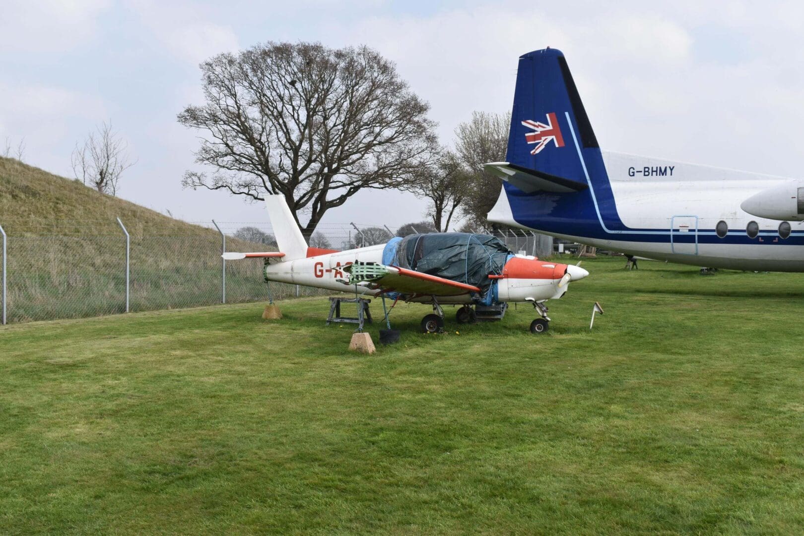 Two parked airplanes on grassy field.