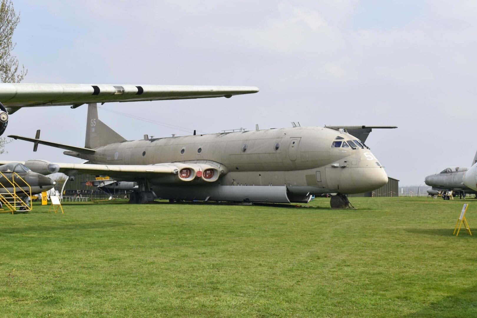 Military aircraft displayed on grassy field.