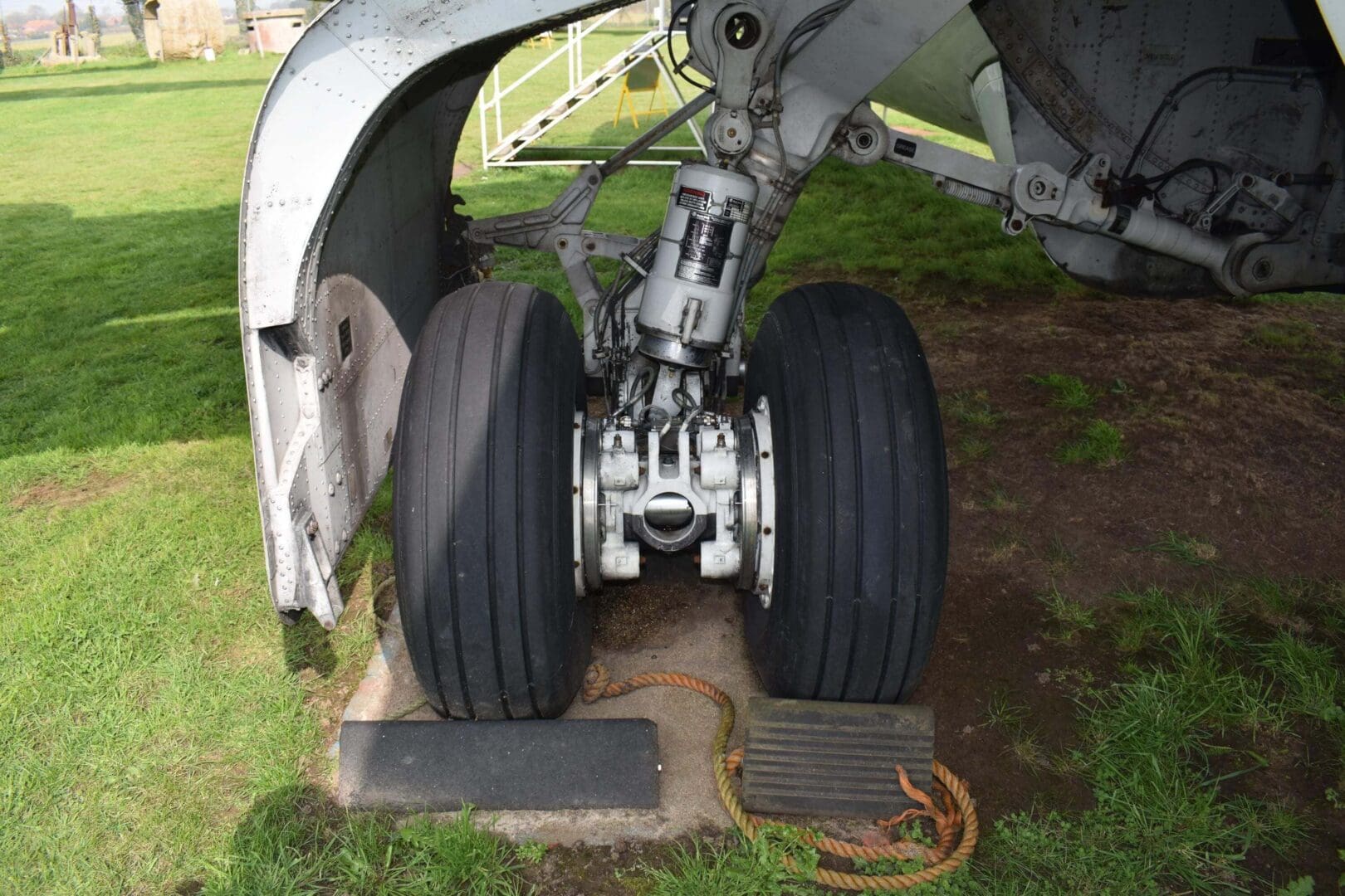 Airplane landing gear on grass surface.
