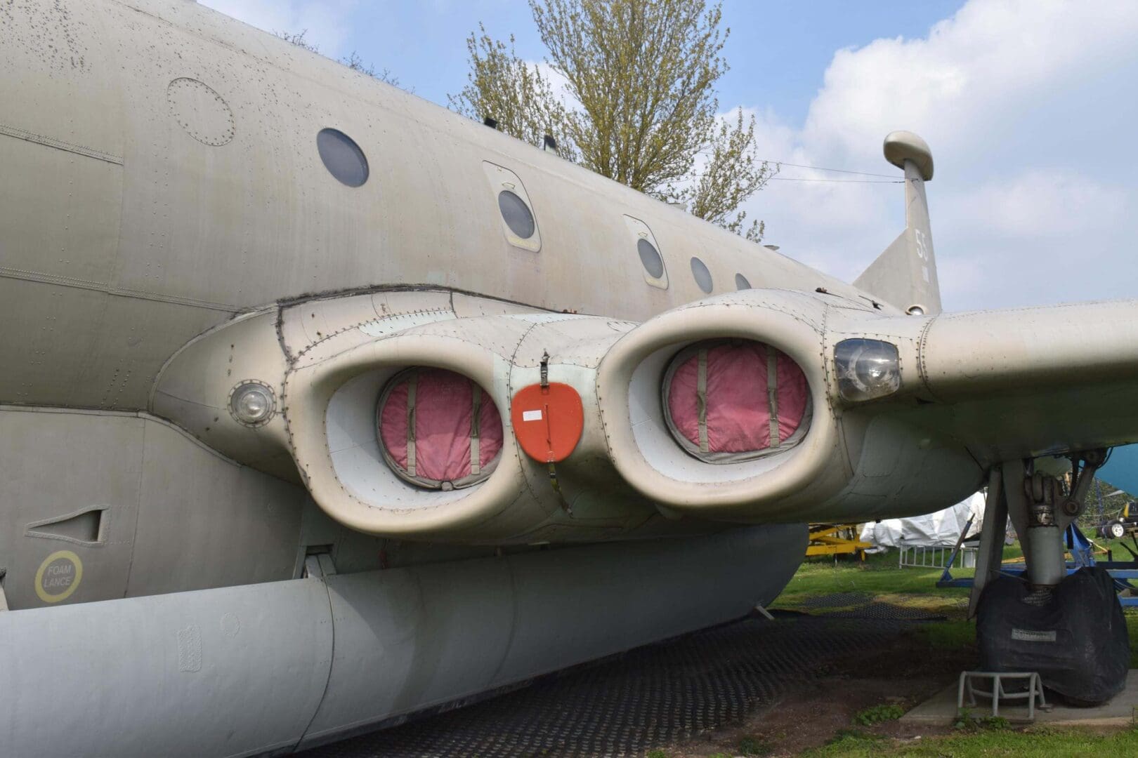 Aircraft engines covered for maintenance, outdoor setting.