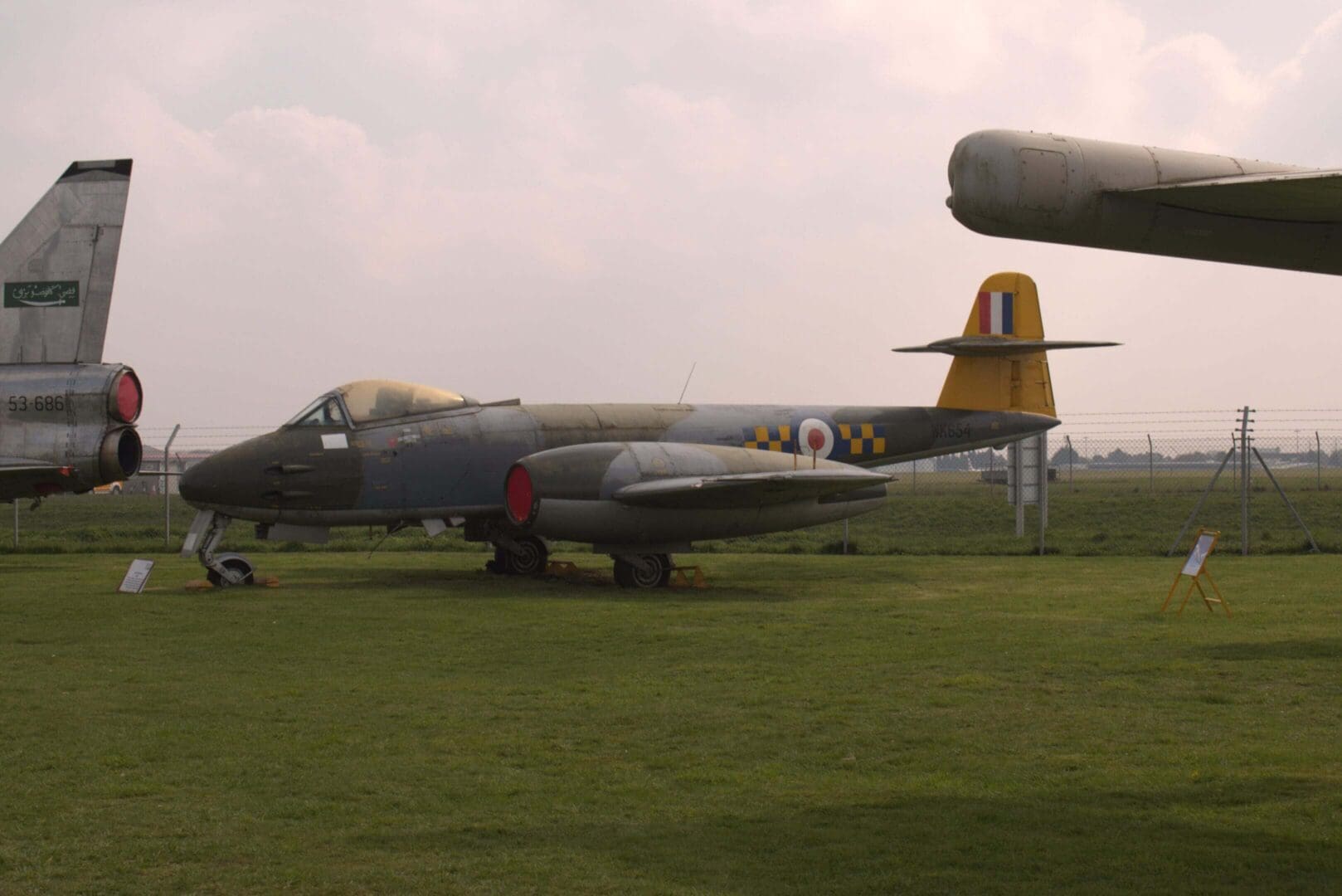 Vintage military jet displayed on grass field.