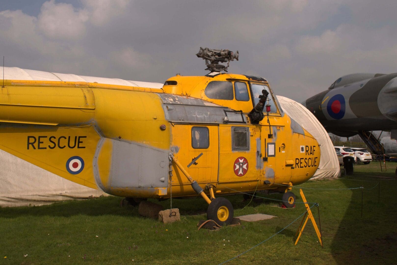 Yellow RAF rescue helicopter on display outdoors.