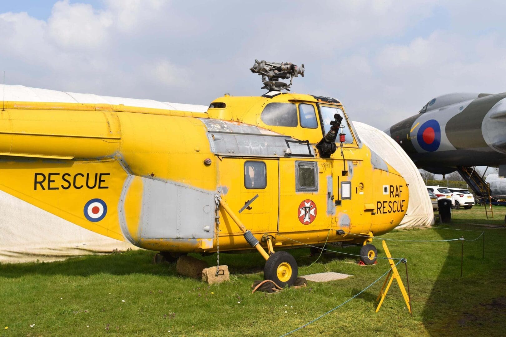 Yellow RAF rescue helicopter on display outdoors.