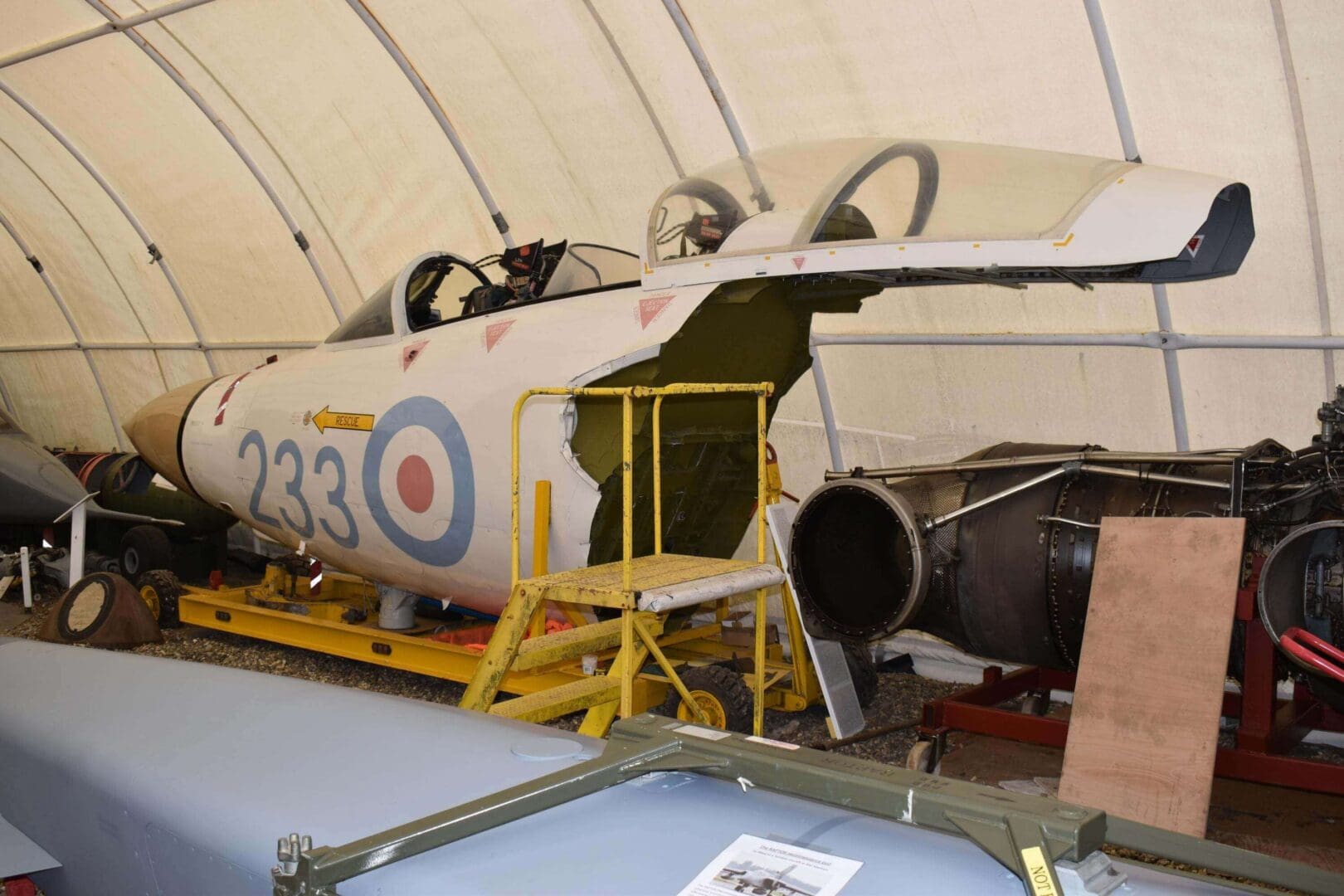 Vintage military jet in restoration hangar.
