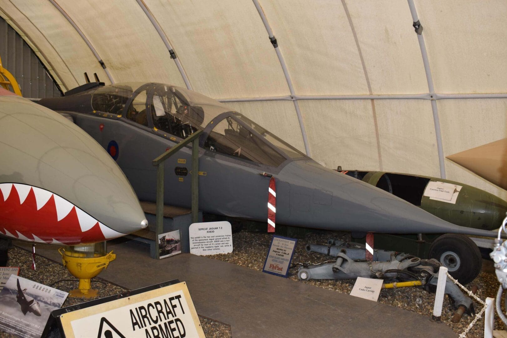 Two military jets displayed in hangar.