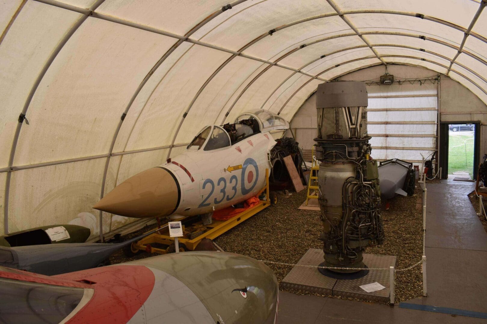 Aircraft and engine in a museum hangar.