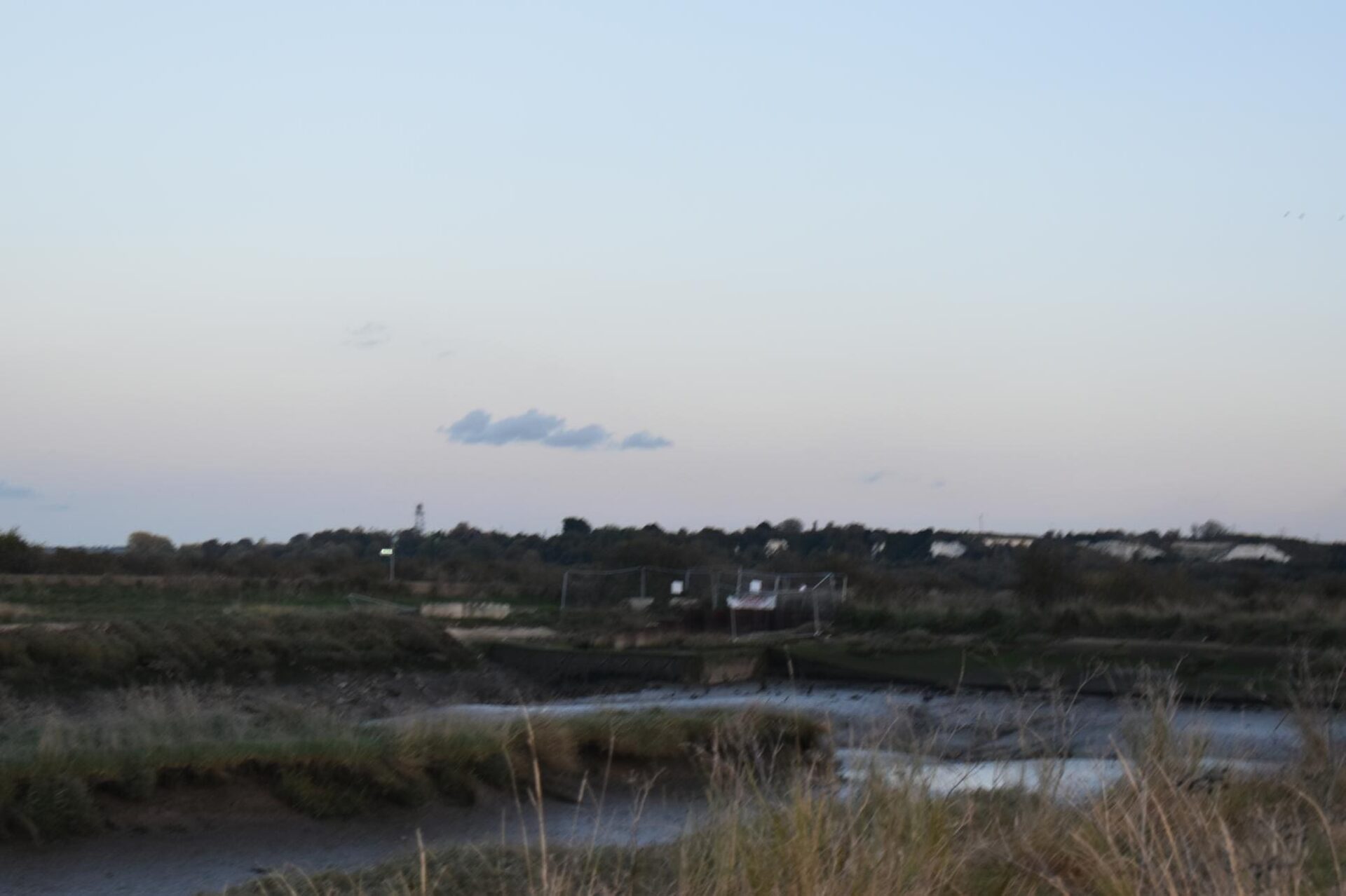 Dusk over a rural landscape with water.