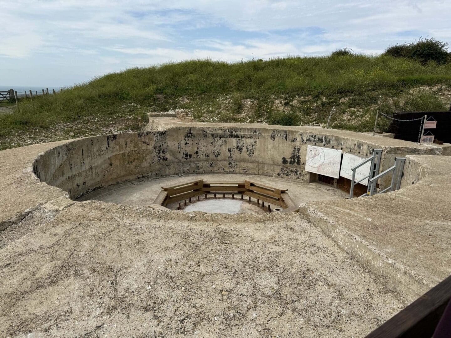 Concrete pit with benches in grassy area.