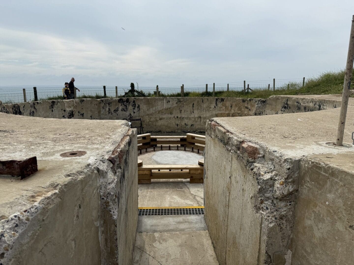 Concrete bunker overlooking the sea, cloudy sky.