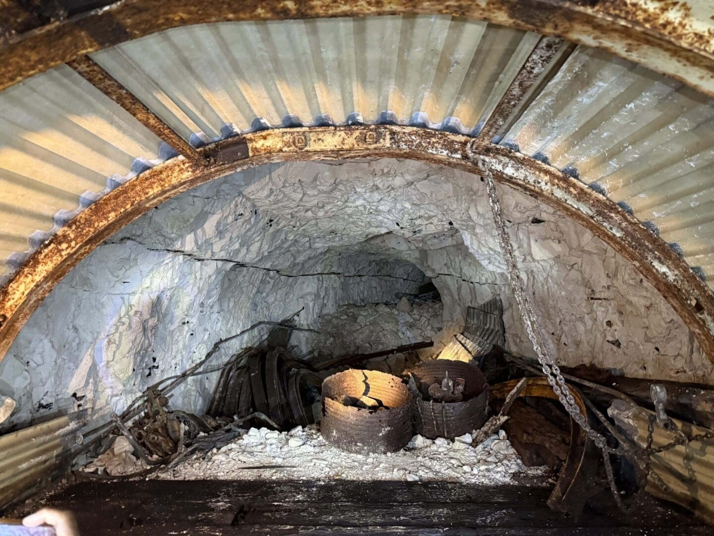 Abandoned mine tunnel with rusty metal debris.